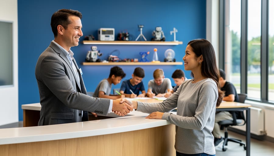 Franchise owner in a modern tutoring center shaking hands with a parent at reception, with students collaborating at tables and STEM robotics kits on shelves in a softly lit, contemporary space.